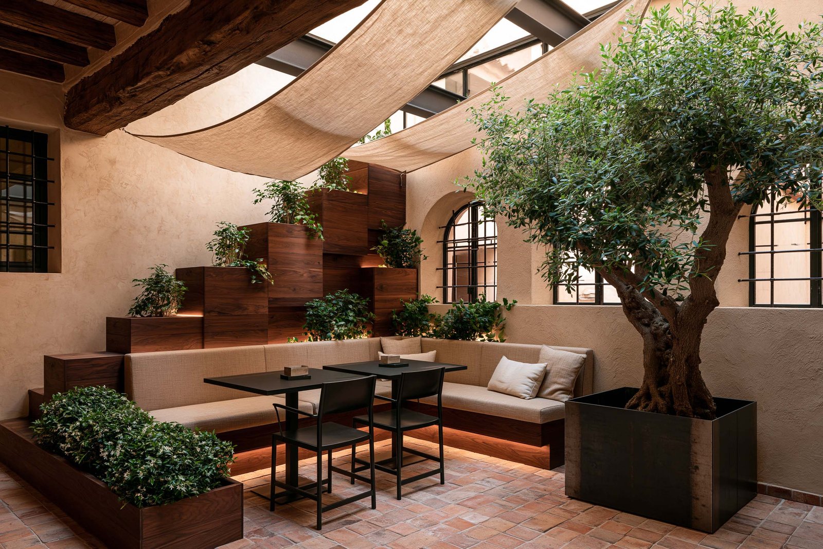 Patio immersif à Saint-Paul-de-Vence sous voiles textiles tendus, olivier mature et jardinières murales en gradins, terrasse comme architecture vivante.