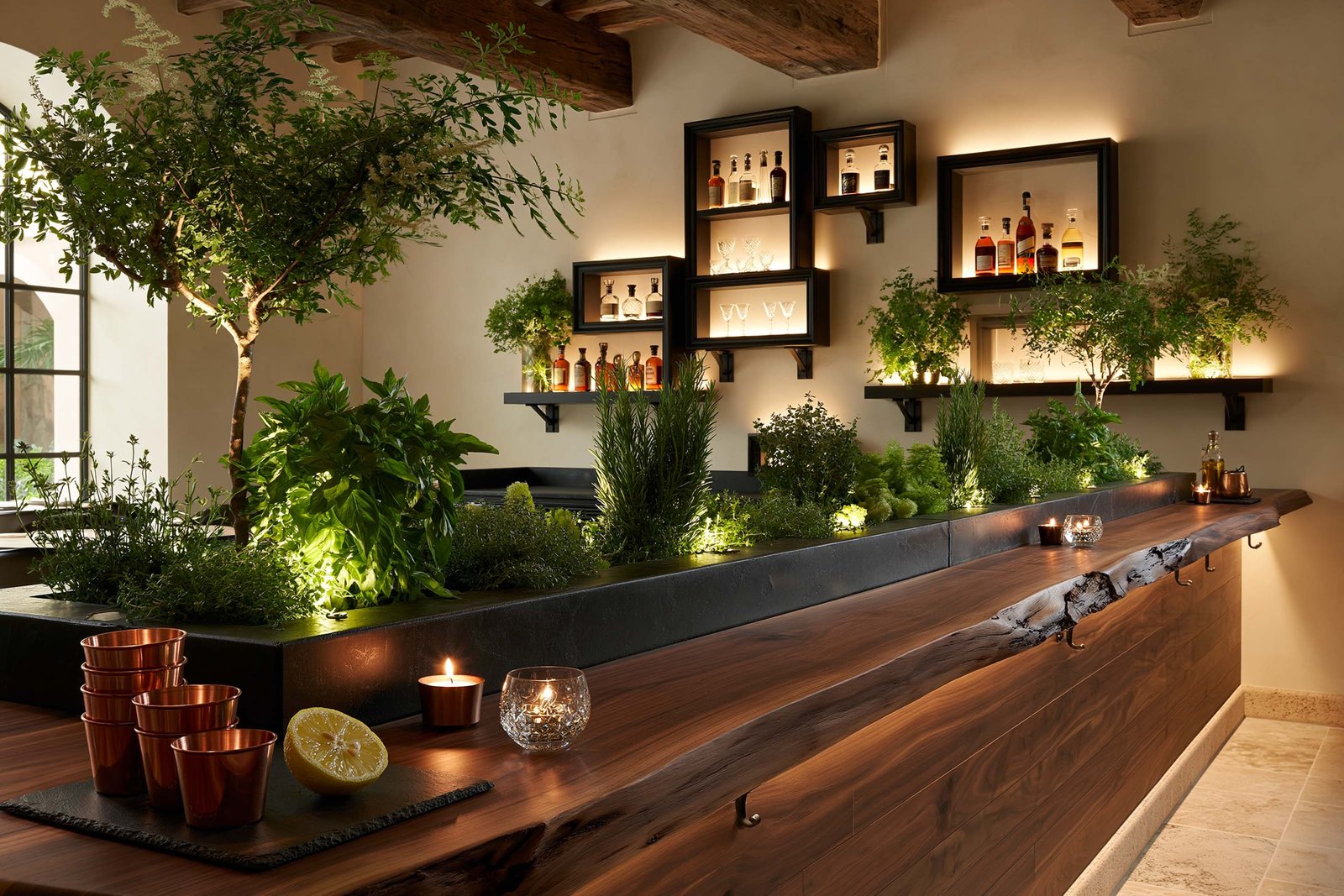 Bancone Apotheca à Beaulieu-sur-Mer, longue dalle live-edge en noyer fumé avec auge intégrée plantée de basilic, romarin et thym, étagères Hortus Velum Arcana rétro-éclairées.