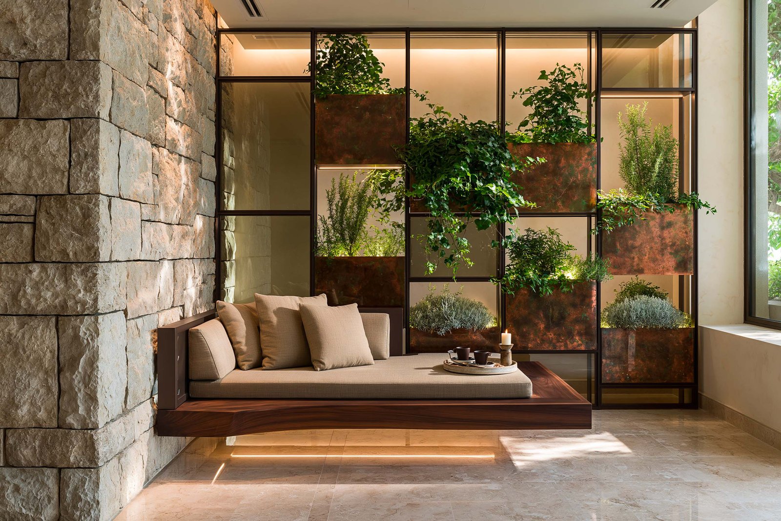 Alcôve d’activation d’un spa à Cap-Ferrat, partition Hortus Velum Arcana en grille acier noirci séquencée avec caissons végétalisés, banquette basse noyer fumé rétro-éclairée LED 2700K, mur en Pietra Serena texturée.